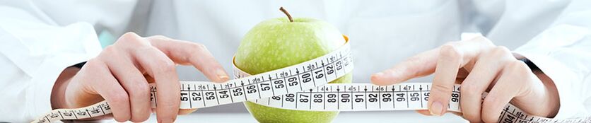 The girl measures the apple with a centimeter tape